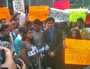 Nadia Habib (at the microphones) speaks at a press conference and rally, with supporters surrounding her